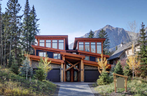 New construction Banff Canmore living room open concept hardwood floors wood contemporary industrial wood stairs metal railings stainless steel appliances steel fireplace wood roof feature white wood wall timberframe front entrance