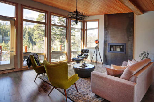 New construction Banff Canmore living room open concept hardwood floors wood contemporary industrial wood stairs metal railings stainless steel appliances steel fireplace wood roof feature white wood wall 