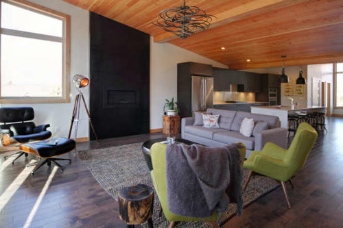 New construction Banff Canmore living room open concept hardwood floors wood contemporary industrial wood stairs metal railings stainless steel appliances steel fireplace wood roof feature white wood wall 