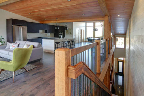 New construction Banff Canmore living room open concept hardwood floors wood contemporary industrial wood stairs metal railings stainless steel appliances steel fireplace wood roof feature white wood wall 