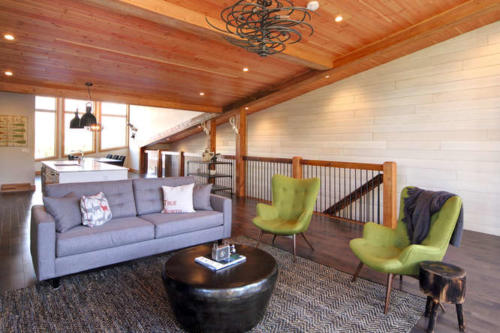 New construction Banff Canmore living room open concept hardwood floors wood contemporary industrial wood stairs metal railings stainless steel appliances steel fireplace wood roof feature white wood wall 