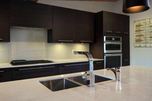 New construction Banff Canmore white kitchen room open concept hardwood floors wood contemporary industrial wood stairs metal railings stainless steel appliances steel fireplace wood roof feature white wood wall 