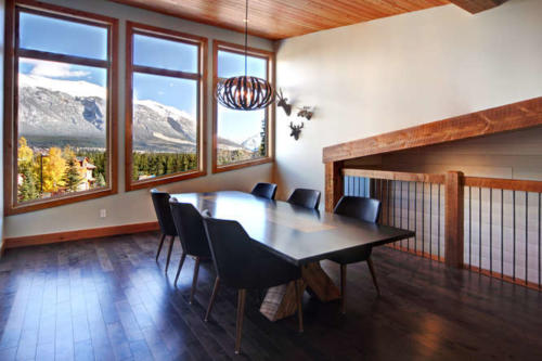 New construction Banff Canmore white kitchen room open concept hardwood floors wood contemporary industrial wood stairs metal railings stainless steel appliances steel fireplace wood roof feature white wood wall 