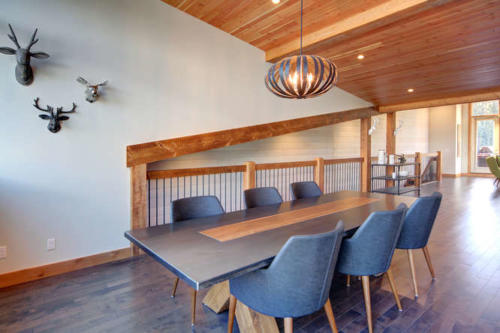 New construction Banff Canmore white kitchen room open concept hardwood floors wood contemporary industrial wood stairs metal railings stainless steel appliances steel fireplace wood roof feature white wood wall 