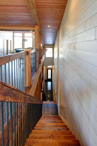 New construction Banff Canmore white kitchen room open concept hardwood floors wood contemporary industrial wood stairs metal railings stainless steel appliances steel fireplace wood roof feature white wood wall 