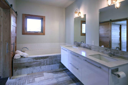 New construction Banff Canmore master ensiute bathroom room open concept hardwood floors wood contemporary industrial wood stairs metal railings wood barn doors white wood tile 