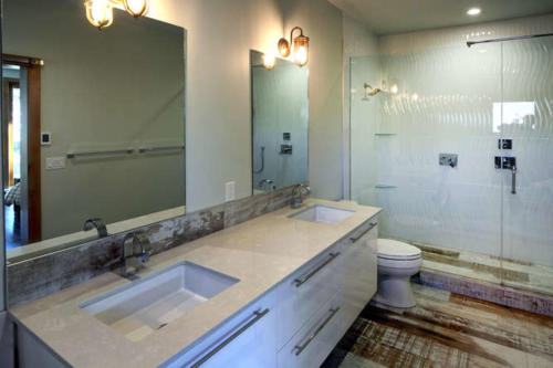 New construction Banff Canmore master ensuite bathroom open concept hardwood floors wood contemporary industrial wood stairs metal railings wood barn doors white wood tile floors