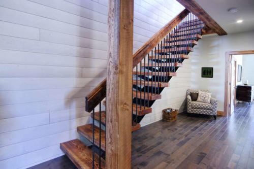 New construction Banff Canmore wood metal stairs open concept hardwood floors contemporary industrial metal railings wood barn doors white wood feature wall