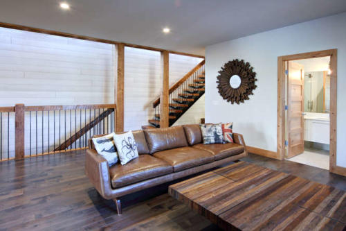 New construction Banff Canmore family room open concept hardwood floors wood contemporary industrial wood stairs metal railings wood barn doors 