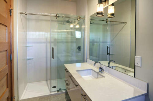 New construction Banff Canmore bathroom open concept hardwood floors wood contemporary industrial wood stairs metal railings glass doors 