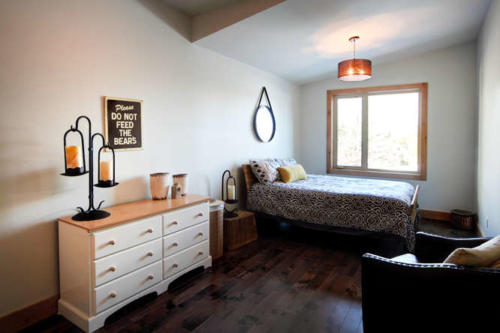 New construction Banff Canmore bedroom room open concept hardwood floors wood contemporary industrial wood stairs metal railings wood barn doors 