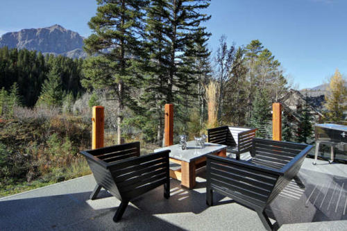 New construction Banff Canmore master bedroom room open concept hardwood floors wood contemporary industrial wood stairs metal railings wood barn doors mountain view decks
