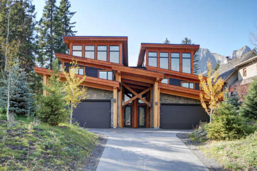 New construction Banff Canmore timberframe stone front entrance open concept hardwood floors wood contemporary industrial wood stairs metal railings wood barn doors 