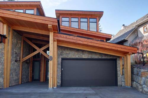 New construction Banff Canmore timberframe stone front entrance open concept hardwood floors wood contemporary industrial wood stairs metal railings wood barn doors 