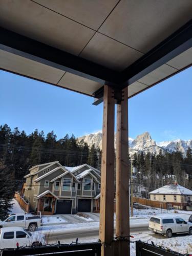 New construction Banff Canmore kitchen dinning room open concept hardwood floors timberframe wood contemporary industrial wood panel ceiling mountain view deck