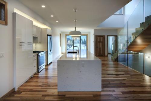 New construction Canmore new construction kitchen hickory wood floors glass railings white kitchen contemporary industrial design 