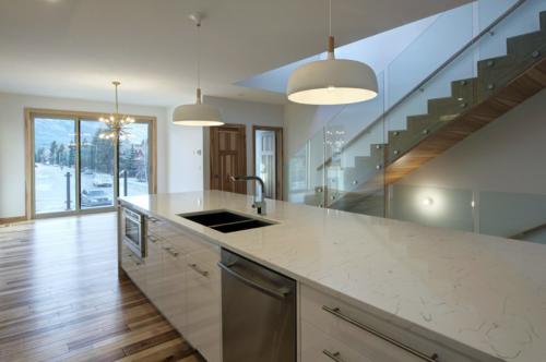 New construction Canmore new construction kitchen hickory wood floors glass railings white kitchen stainless steel appliances wood stairs contemporary industrial design 