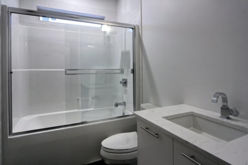 New construction Canmore new construction bathroom polished concrete floors white tile bathroom 