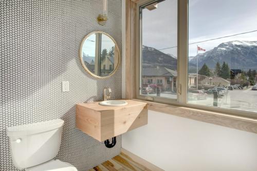 New construction Canmore new construction bathroom hickory wood floors patterned tiles wood timber vanity metal round mirror contemporary industrial design  
