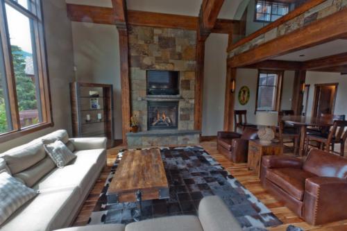 New construction Banff Canmore living room hardwood floors timberframe contemporary industrial design rock fireplace with television glass railings
