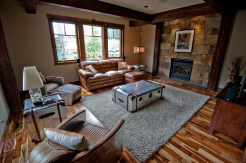 New construction Banff Canmore living room hardwood floors timberframe contemporary industrial design rock fireplace with television