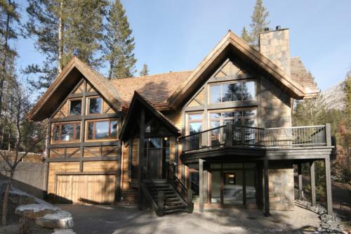 New construction Banff Canmore open concept hardwood floors timberframe wood contemporary industrial wainscoting walls stone fireplace chimney 
