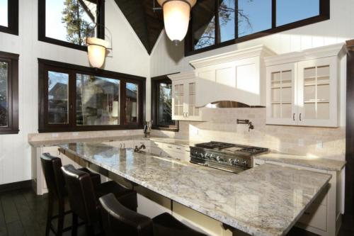 New construction Banff Canmore white wood kitchen open concept hardwood floors timberframe wood contemporary industrial wainscoting walls stone counter tops stainless steel appliances 