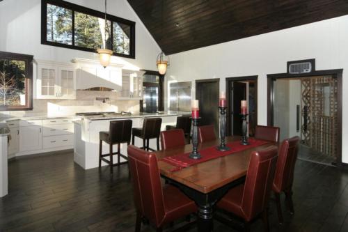 New construction Banff Canmore white wood kitchen dinning room wine room open concept hardwood floors timberframe wood contemporary industrial wainscoting walls stone counter tops stainless steel appliances 