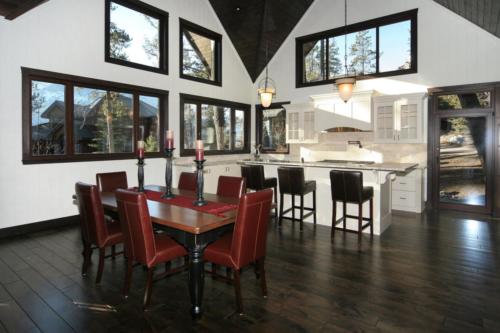 New construction Banff Canmore white wood kitchen open concept hardwood floors timberframe wood contemporary industrial wainscoting walls stone counter tops stainless steel appliances 