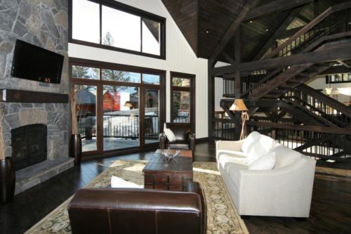 New construction Banff Canmore living room open concept hardwood floors timberframe wood contemporary industrial wainscoting walls stone fireplace