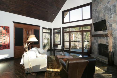 New construction Banff Canmore living room open concept hardwood floors timberframe wood contemporary industrial wainscoting walls stone fireplace