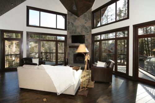 New construction Banff Canmore living room open concept hardwood floors timberframe wood contemporary industrial wainscoting walls stone fireplace