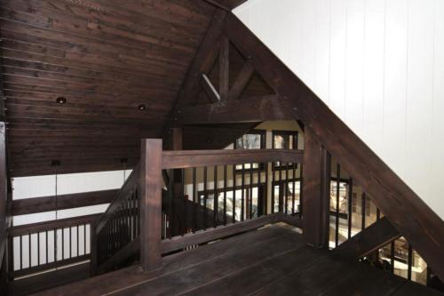 New construction Banff Canmore living room open concept hardwood floors timberframe wood contemporary industrial wainscoting walls wood stairs metal railings 