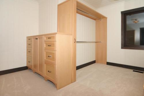 New construction Banff Canmore master bedroom walk-in closet built-ins open concept hardwood floors timberframe wood contemporary industrial wainscoting walls wood 