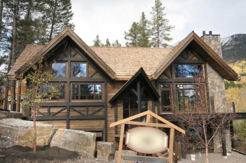 New construction Banff Canmore open concept hardwood floors timberframe wood contemporary industrial wainscoting walls wood stairs metal railings stainless steel appliances stone fireplace 