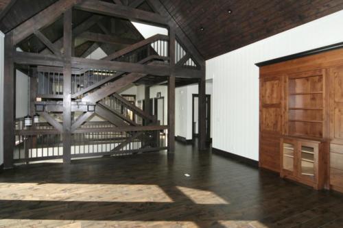 New construction Banff Canmore living room open concept hardwood floors timberframe wood contemporary industrial wainscoting walls wood stairs metal railings stainless steel appliances stone counter tops