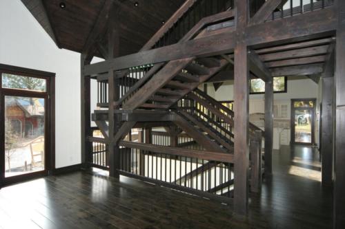 New construction Banff Canmore wood stairs open concept hardwood floors timberframe wood contemporary industrial wainscoting walls wood stairs metal railings stainless steel appliances stone fireplace 