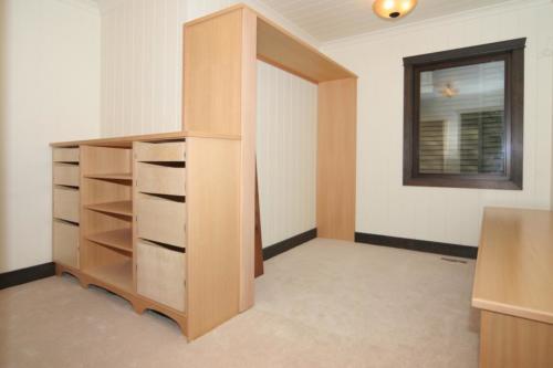 New construction Banff Canmore master bedroom walk-in closet with built-ins open concept hardwood floors timberframe wood contemporary industrial wainscoting walls wood  stone fireplace 