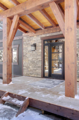 New construction Banff Canmore timberframe stone front entrance open concept hardwood floors wood contemporary industrial wood stairs metal railings wood barn doors 