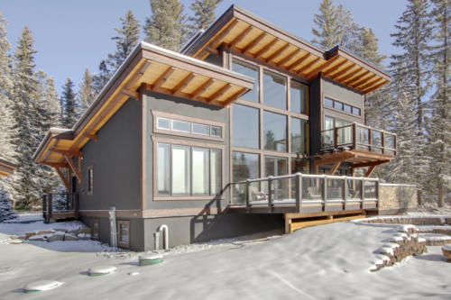 New construction Banff Canmore timberframe stone front entrance open concept hardwood floors wood contemporary industrial wood stairs metal railings wood barn doors 