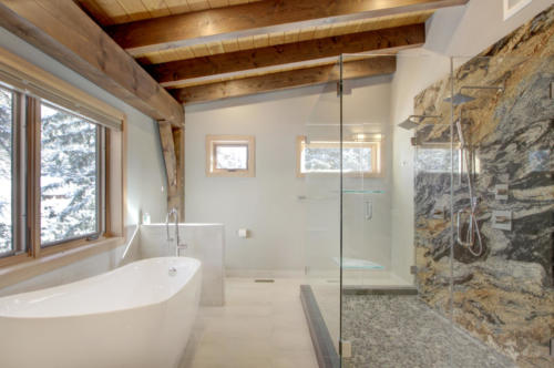 New construction Banff Canmore master bathroom ensuite room steel fireplace timberframe open concept hardwood floors wood contemporary industrial wood stairs metal railings wood barn doors 