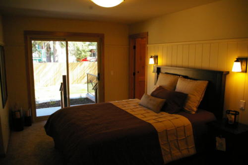 New construction Banff Canmore master bedroom open concept hardwood floors wood contemporary industrial wood stairs metal railings wainscoting walls 